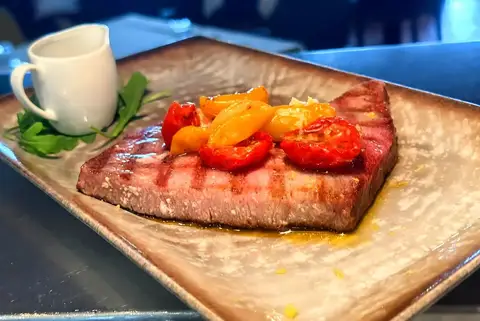 Taglio di carne grigliata con pomodorini e condimento essenziale
