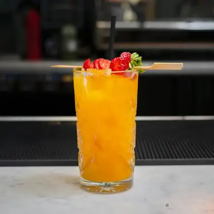 Cocktail arancione servito in bicchiere basso